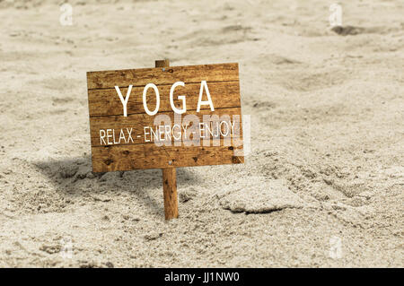 Yoga panneau en bois sur une plage de sable. Vous pourrez vous détendre et profiter de l'énergie, concept. Banque D'Images