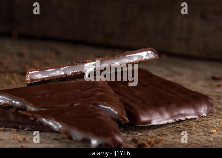 Morceaux de chocolat avec crème de menthe sur fond rustique en bois Banque D'Images