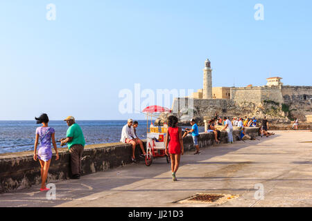 Peuple cubain vous détendre sous le soleil d'après-midi sur le Malecon, La Habana Vieja, La Havane, Cuba Banque D'Images