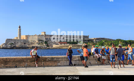 Les pêcheurs sur le Malecon, le Castillo de los Tres Reyes del Morro derrière, La Vieille Havane, Cuba Banque D'Images