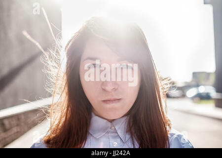 Grumpy têtu jeune femme avec de longs cheveux et des joues tacaud tout en se sentant en colère. Banque D'Images