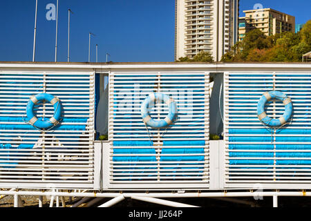 Bouée bleu accroché sur la paroi en bois tente de plage de galets sur le rivage d'une côte en ville Sotchi. Vacances de plage de détente en été pour se tente. Archi Banque D'Images