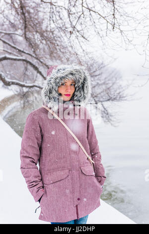 Jeune femme en manteau d'hiver à marcher le long du bassin de marée au cours de tempête de neige à Washington DC Banque D'Images