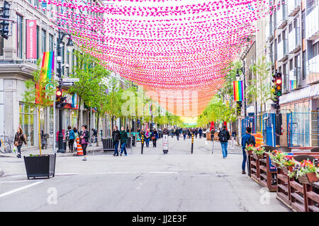 Montréal, Canada - le 26 mai 2017 : Les gens de marcher sur la rue Sainte Catherine dans le Village gai de Montréal dans la région du Québec avec des décorations suspendues Banque D'Images