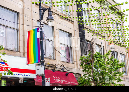 Montréal, Canada - le 26 mai 2017 : La rue Sainte-Catherine dans le Village gai de Montréal dans la région du Québec avec des décorations suspendues vert et drapeau lgbt Banque D'Images