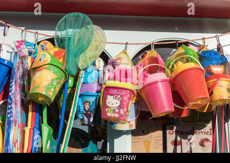 Seaux, pelles et les filets de pêche accrochée pour vente dans une station shop. Banque D'Images