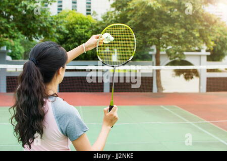 Fille de service sur un match de badminton sur la cour à l'extérieur Banque D'Images