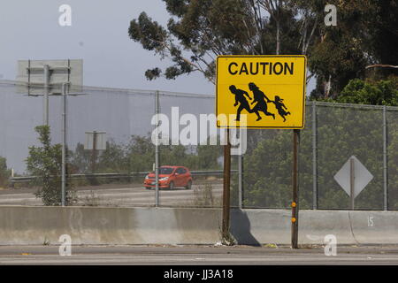 San Ysidro, CA, USA. 17 juillet, 2017. La dernière des dix panneaux indicateurs de passage à niveau d'immigrants qui se dressait autrefois sur chaque côté de Interstates 5 et de l'Interstate 805, près de la frontière américano-mexicaine est encore visible à San Ysidro, CA. Caltrans a dit que ce dernier ne sera pas remplacé une fois qu'il est parti. Les panneaux ont été créés à partir de photos prises par l'ancien photographe du Los Angeles Times, Don Bartletti et créé par Caltrans employé John Hood au début des années 1990 après un certain nombre de décès sont survenus sur l'autoroute quand le secteur de patrouille à la frontière de San Diego a été littéralement envahi par les migrants de traverser. (Crédit Image : © John Banque D'Images