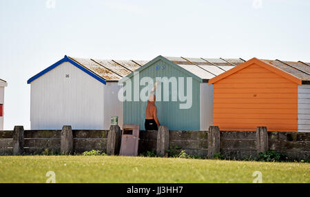 Lancing Sussex, UK. 18 juillet, 2017. Le temps de peindre la cabane de plage sur un beau jour ensoleillé chaud à Lancing beach près de Worthing mais les orages et la pluie sont à prévoir pour les prochains jours au Royaume-Uni Crédit : Simon Dack/Alamy Live News Banque D'Images