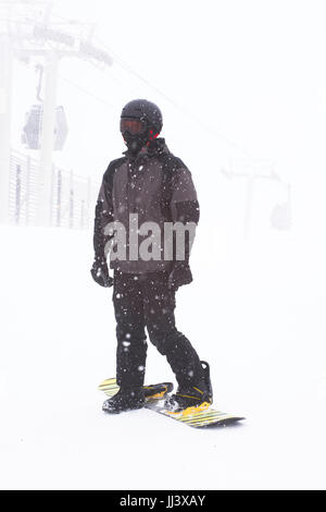 Snowboarder debout au sommet d'une montagne Banque D'Images