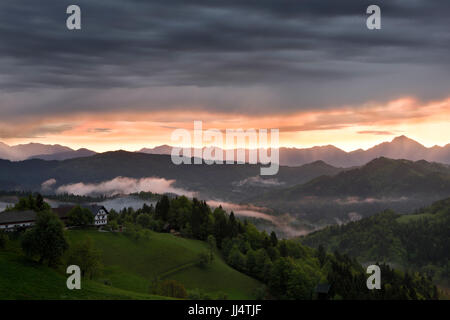 Lever du soleil avec la brume sur les montagnes de Kamnik Savinja Alps avec Storzic dans Skofjelosko pointe droit sur collines près de Ljubljana Slovénie Banque D'Images