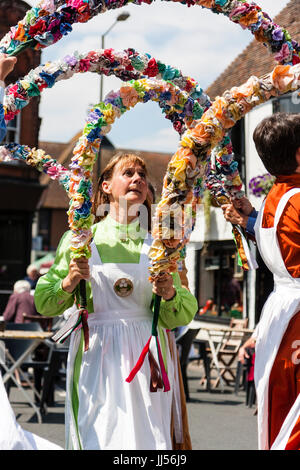 Danseurs folkloriques traditionnels anglais, les femmes de la Noeuds de May Morris, danser dans la rue maintenant demi-cercle des guirlandes de fleurs sur la tête. Banque D'Images