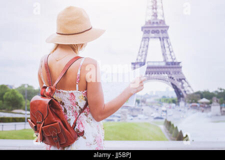 Les touristes à la recherche sur la carte de la ville de Paris, à proximité de la Tour Eiffel, le tourisme en France Banque D'Images