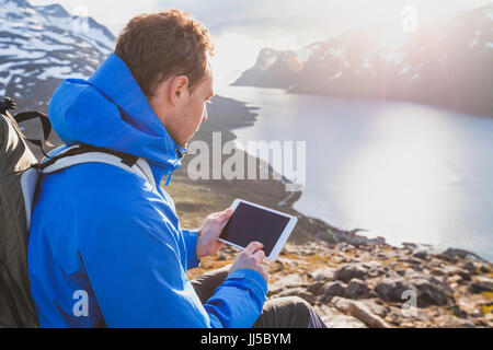 Meilleur backpacker using digital tablet ordinateur à l'extérieur en montagne, voyage en ligne application mobile Banque D'Images