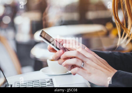 Femme hands holding smartphone sur arrière-plan de la ville Banque D'Images