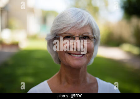 Portrait of smiling senior woman wearing eyeglasses at park Banque D'Images