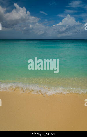 Une petite vague s'écrase sur Seven Mile Beach Grand Cayman. Banque D'Images