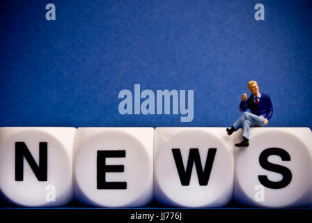 Figurine miniature assis sur dice avec word NEWS Banque D'Images