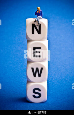 Figurine miniature assis sur dice avec word NEWS Banque D'Images