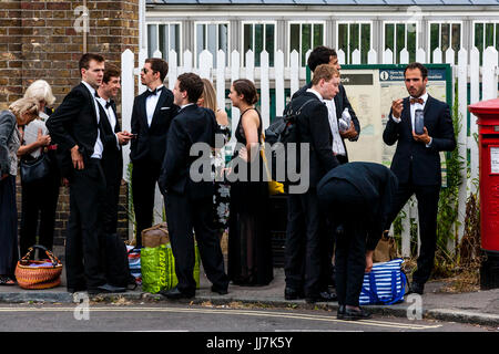 Les jeunes amateurs d'opéra avec leurs paniers pique-nique arrivent à la gare de Lewes, en route vers l'opéra de Glyndebourne, Lewes, dans le Sussex, UK Banque D'Images