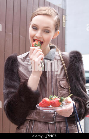 Fashion model eating une fraise pendant la Fashion Week de New York Banque D'Images