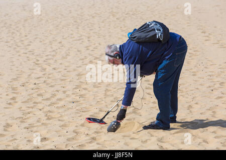 L'homme, chasseur de trésor avec détecteur de métal à la recherche de trésors à la plage de Bournemouth, Bournemouth, Dorset UK en Juillet Banque D'Images