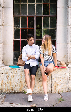 Joli couple teenage student posing in front of university. Banque D'Images