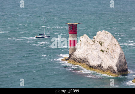 Yacht se rendant autour des aiguilles à l'île de Wight, Hampshire, Angleterre Royaume-Uni en juillet - aiguilles phare et formation de la pile de craie de roche Banque D'Images