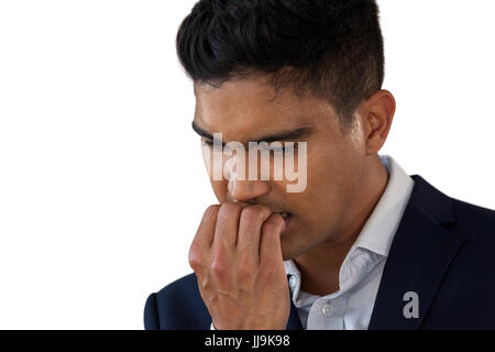 Close up of inquiets businessman biting nails against white background Banque D'Images