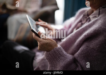 Portrait senior woman using digital tablet à maison de retraite Banque D'Images