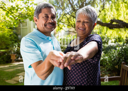 Couple dansant dans le jardin sur une journée ensoleillée Banque D'Images