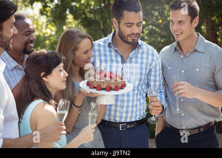 Groupe d'amis pour célébrer l'anniversaire de womans au restaurant en plein air sur une journée ensoleillée Banque D'Images