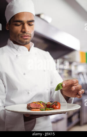 Chef holding plat délicieux dans la cuisine au restaurant Banque D'Images