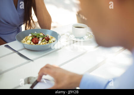Section intermédiaire de femme ayant une salade de légumes au restaurant Banque D'Images
