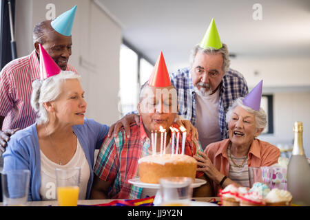 À la recherche d'amis à man smearing cake au cours de partie en maison de soins infirmiers Banque D'Images