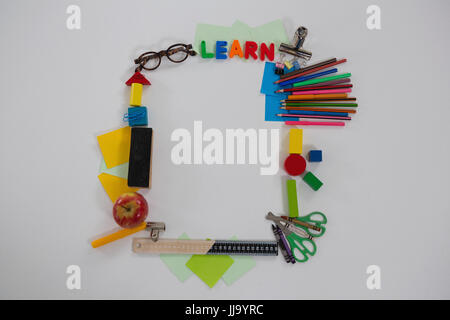 Vue aérienne de diverses fournitures scolaires organisés sur fond blanc Banque D'Images