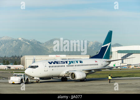 Boeing 737 de Westjet remorqué sur le tarmac de l'Aéroport International de Vancouver. Banque D'Images