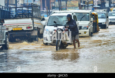 Jodhpur, Inde. 19 juillet, 2017. Un homme pousse son vélo dans la rue inondée à Nagarjan à Jodhpur, Inde du nord-est de l'état de Nagaland. La pluie de mousson incessante dans l'effet région vie normale causant des inondations et des glissements de la coupe de la route nationale. Credit : Caisii Mao/Alamy Live News Banque D'Images