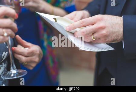 Récemment Mariés - La main du marié et l'enveloppe de certificat de mariage Banque D'Images