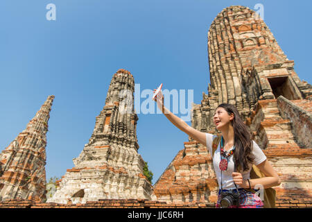 Smartphone selfies girl taking photo téléphone mobile sur wat chaiwatthanaram,temple Ayutthaya. Young Asian woman backpacker sourire posant pour avoir l'appareil photo Banque D'Images