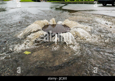 Accident d'égouts. L'eau coule sur la route de l'égout. Banque D'Images