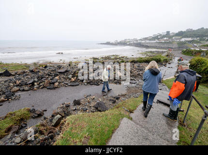 Les passants regarder des débris sur la route dans la région de Coverack, Cornwall, après d'intenses pluies provoquant inondations dans le village côtier. Banque D'Images