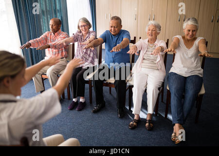 Femme médecin exerçant avec des personnes en maison de retraite Banque D'Images