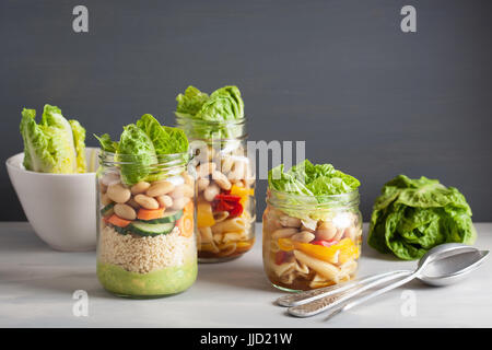 Salade de pâtes et de couscous végétalien dans des pots Mason avec haricots Légumes Banque D'Images