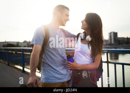 Photo de young attractive couple carrying skateboards Banque D'Images