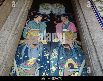 Les peintures de conte de fées sur la porte en bois à un ancien temple Chinois de Penang, en Malaisie. Banque D'Images
