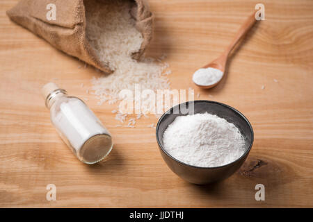 Riz blanc au jasmin dans un sac et farine de riz sur la table en bois. Banque D'Images