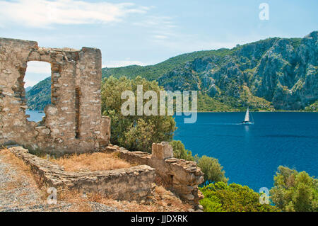 Ruines médiévales de l'église byzantine avec yacht blanc dans la mer Égée et les montagnes en arrière-plan, Marmaris, Turquie Banque D'Images