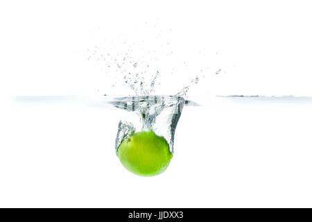 Lime douce largué dans l'eau avec de l'eau splash sur un fond blanc Banque D'Images