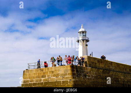 Les vacanciers à la recherche de Smeaton's pier par le phare à St Ives, Cornwall Banque D'Images